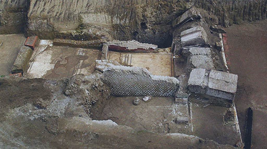 House of Dionysiac Reliefs, Herculaneum, seaside pavilion, 2009, rooms (a) to (f).
Rooms (a), (b) and (c) were richly decorated.
Room (a) was a cubiculum diurnum with the alcove for the day bed marked off on the mosaic floor by a row of white triangles on a black ground.
Room (c) was also a cubiculum diurnum with the mosaic floor with a frieze marking off the rear alcove composed of whjite tesserae laid diagonally, surrounded by a double band of black tesserae laid orthogonally.
Room (b) was a great banqueting hall with a tripartite entrance and a pavement in diamond patterned opus sectile which had already been removed at the time of the eruption, showing that this part of the complex was undergoing restoration.
See Guidobaldi, M.P. and Esposito D., 2013. Herculaneum: Art of a Buried City. New York: Abbeville Press, p. 151, fig. 124.